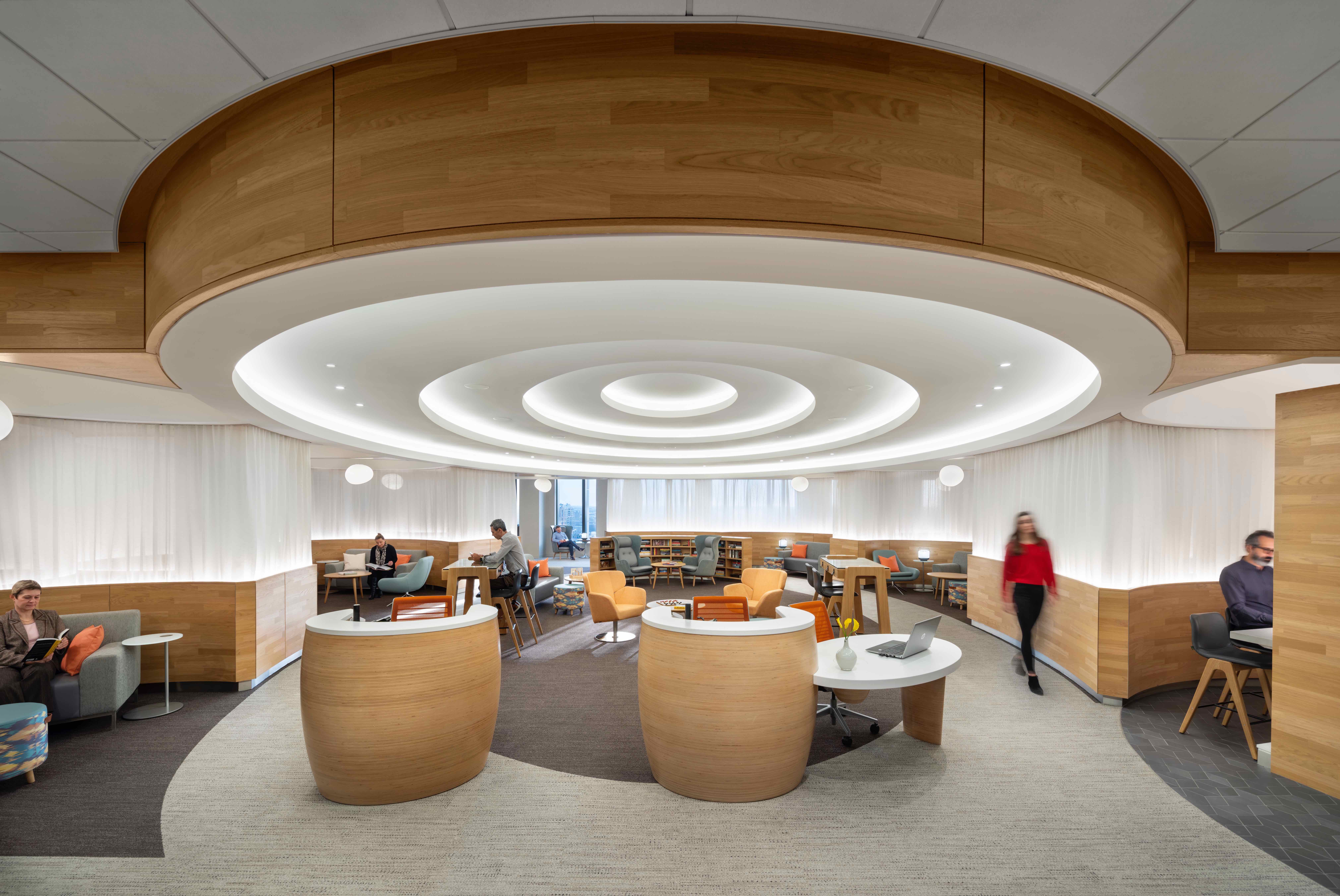 Modern office lounge with circular lighting and wooden accents