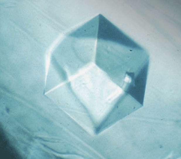 Transparent cubic crystal on light background